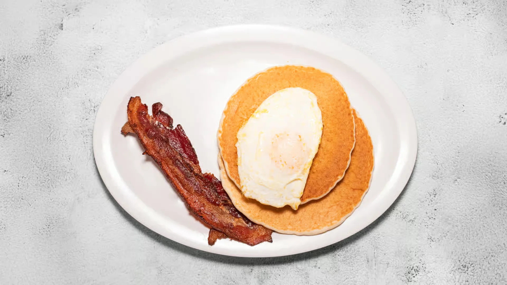 Hasty Tasty Breakfast - 1 egg, 2 pancakes, and choice of bacon or sausage